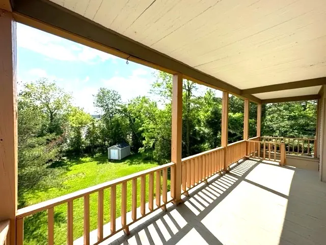 Covered porch overlooking the large wooded backyard