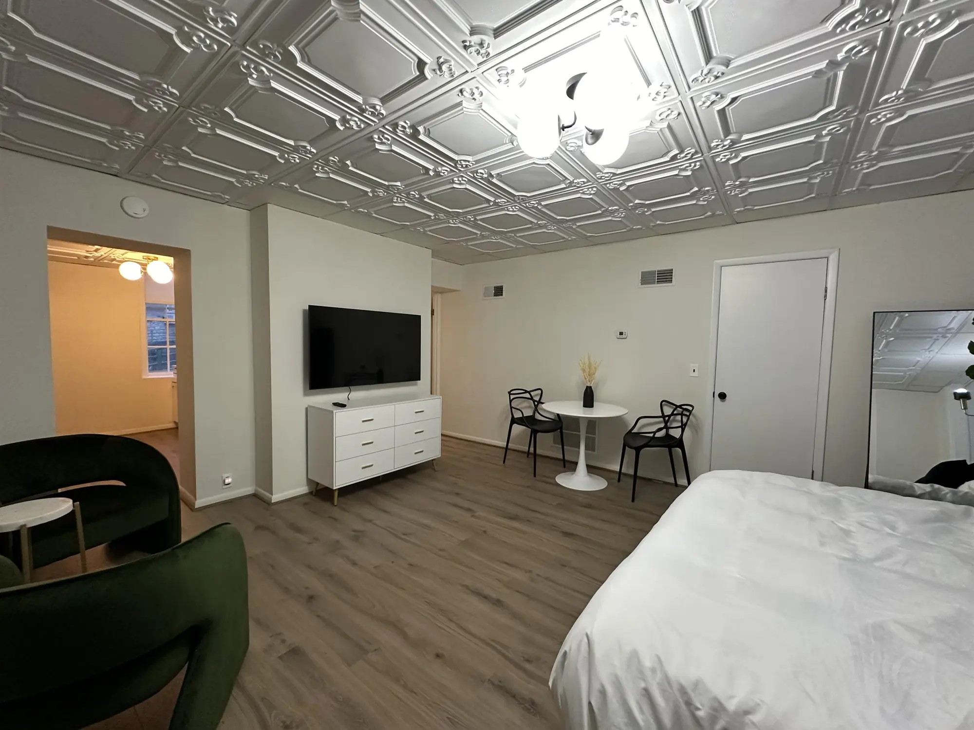 Bedroom and sitting area under a pressed-tin ceiling
