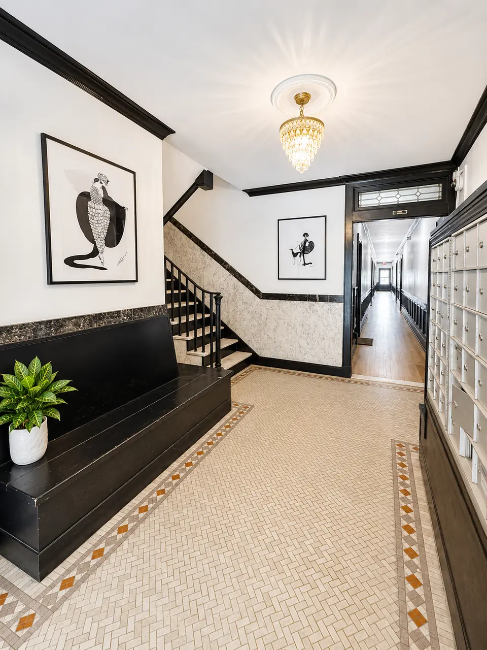 The Biltmore lobby: herringbone mosaic floor, crystal chandelier and a black staircase